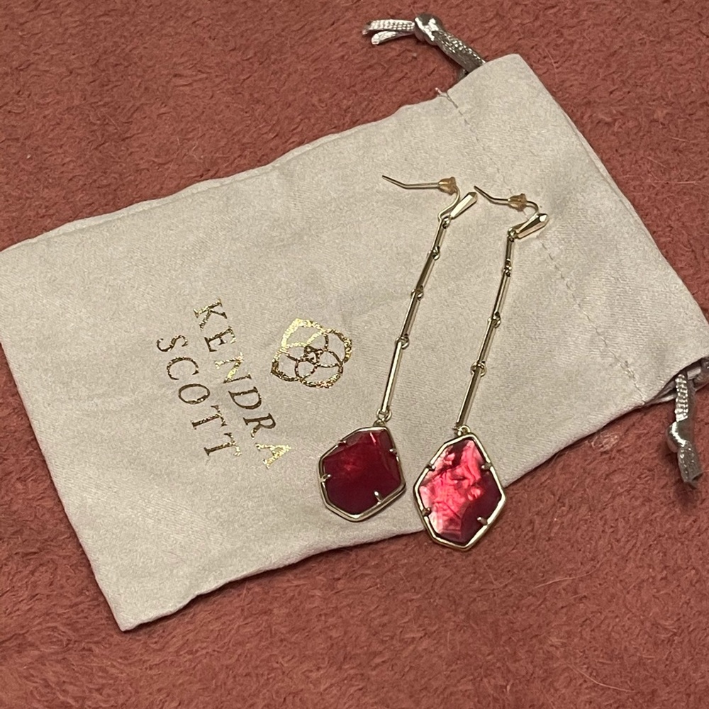 Kendra Scott long gold earrings with a  pink stone